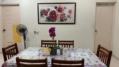 a dining room table with purple flowers on it at Tamu House Botani in Ipoh