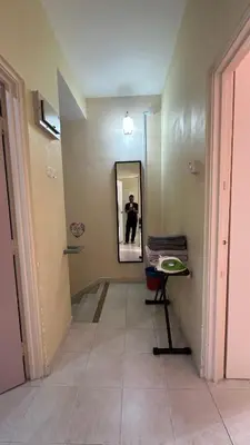 a hallway with a person taking a picture in a mirror at Tamu House Botani in Ipoh