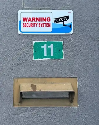 a sign for a security system on a wall at Tamu House Botani in Ipoh