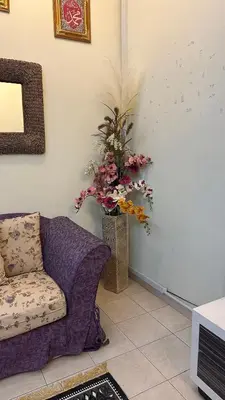 a living room with a couch and a vase of flowers at Tamu House Botani in Ipoh