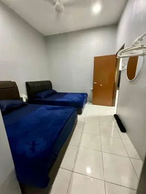 a small room with two beds and a door at Impiana Pool House Seri Manjung in Seri Manjung