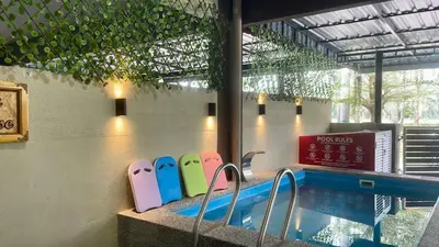 a swimming pool with colorful chairs in front of a building at Impiana Pool House Seri Manjung in Seri Manjung