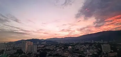 a sunset over a city with buildings and mountains at Beacon Executive Suites George Town Apartment Malaysia deals in George Town
