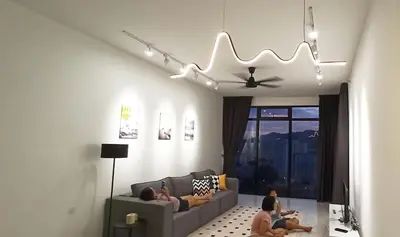 a living room with two people sitting on a couch at Beacon Executive Suites George Town Apartment Malaysia deals in George Town