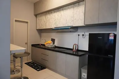 a kitchen with a black refrigerator and a counter at The Horizon Ipoh Infinity Pool 5 to 9pax in Ipoh
