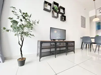 a living room with a tv and a potted tree at Beacon Executive Suites #Minimalist #SkyPool #Georgetown #6pax #2BR 2bath #3 Queen #Quality well maintained #Private host in George Town