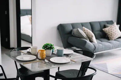 a table with four chairs and a couch at NEW Infinity Pool 3 Bedrooms 2 Carparks 197 in Jelutong