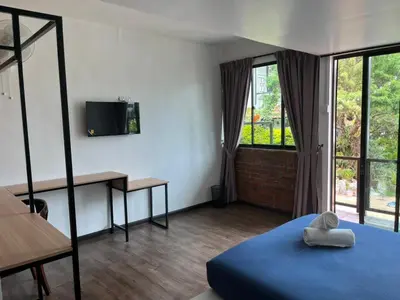 a bedroom with a bed and a desk and window at Big Dreams Garden Stay in Tanah Rata
