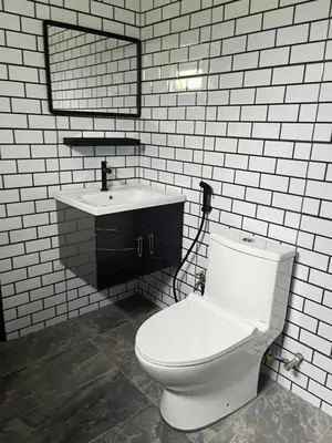 a bathroom with a white toilet and a sink at Big Dreams Garden Stay in Tanah Rata