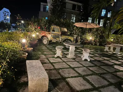 a stone patio with a table and an umbrella at Big Dreams Garden Stay in Tanah Rata