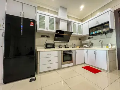 a kitchen with white cabinets and a black refrigerator at Taiping City View 3BR Condo near Lake Garden with Sunset View & Swimming Pool, Free Netflix WiFi in Taiping