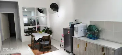 a kitchen with a counter and a table with a microwave at FIRASH HOMESTAY AT SERI ISKANDAR in Seri Iskandar