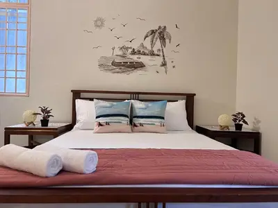 a bedroom with a large bed with two night stands at EE's Sunset House - Homestay 3 min walk to beach in Batu Ferringhi