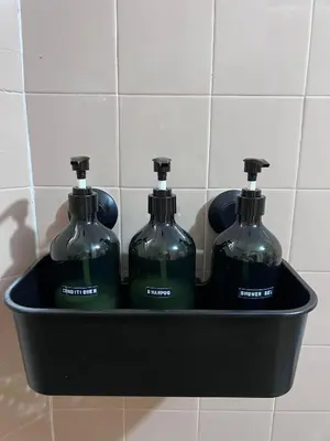 three bottles of soap in a black container on a wall at EE's Sunset House - Homestay 3 min walk to beach in Batu Ferringhi