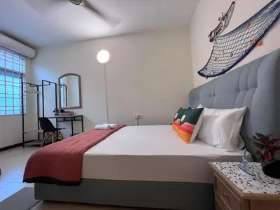a bedroom with a bed with a net on the wall at EE's Sunset House - Homestay 3 min walk to beach in Batu Ferringhi