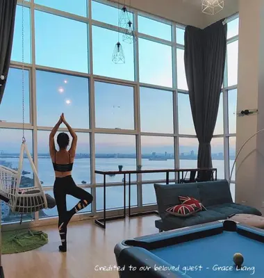 a woman doing yoga in front of a large window at Maritime Suite #Full Seaview #Pool Table #Hot Water Dispenser #Kids friendly #Georgetown #6pax #2BR2bath #Private host in Jelutong