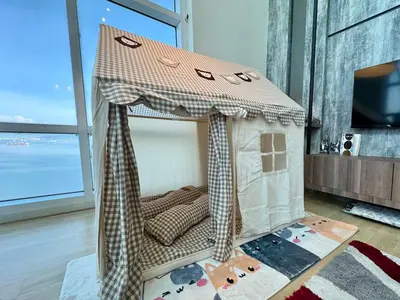 a small bed in a room with a large window at Maritime Suite #Full Seaview #Pool Table #Hot Water Dispenser #Kids friendly #Georgetown #6pax #2BR2bath #Private host in Jelutong