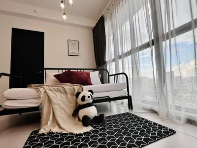 a panda bear sitting on a rug in a bedroom at Urban Suite Cozy Family Homestay at Georgetown by URBAN STAYCATION HENG LOD LUXE in Jelutong