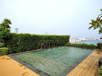 a swimming pool with a hedge and a wooden deck at SkyPool 2BR 9pax Premium Suite@Beacon @Georgetown @Penang in George Town