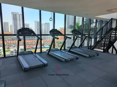 a row of treadmills in a gym with a view at Urban Suites Homestay WL COSY in Jelutong