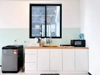 a kitchen with white cabinets and a window at Urban Suites Homestay WL COSY in Jelutong