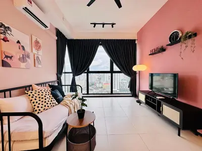 a pink living room with a couch and a tv at Urban Suites Homestay WL COSY in Jelutong