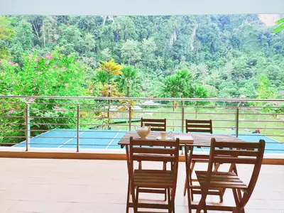 a table and chairs on a patio with a tennis court at IPOH All Suite Resort, Jalan Haven, Persiaran Lembah Perpaduan, Ipoh in Ipoh