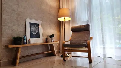 a room with a chair and a table and a lamp at IPOH All Suite Resort, Jalan Haven, Persiaran Lembah Perpaduan, Ipoh in Ipoh