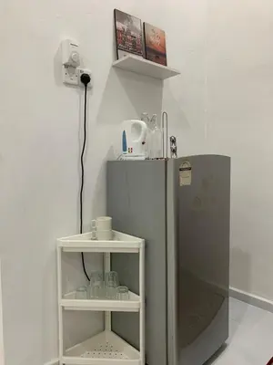 a small refrigerator in a room with a shelf at Rezeki indah Hstay self check in in Bukit Mertajam