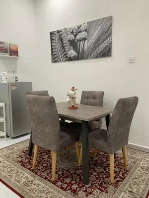 a dining room table with two chairs and a table and a rug at Rezeki indah Hstay self check in in Bukit Mertajam