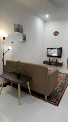 a living room with a couch and a tv at Rezeki indah Hstay self check in in Bukit Mertajam