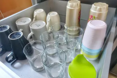 a drawer filled with glasses and other items at Monstera Meritus Homestay - Penang Butterworth Prai 1-8PAX in Perai