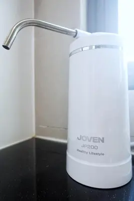 a white juicer sitting on a black counter at Monstera Meritus Homestay - Penang Butterworth Prai 1-8PAX in Perai