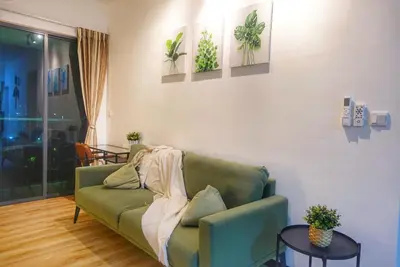 a living room with a green couch and two tables at Monstera Meritus Homestay - Penang Butterworth Prai 1-8PAX in Perai