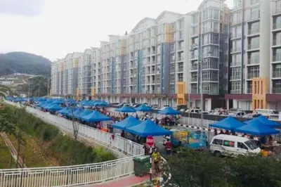 a large building with blue umbrellas in front of it at Cameron Highlands, The Breeze @ Barrington Square in Brinchang