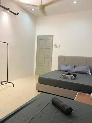 a bedroom with a bed and a rug on the floor at Homestay 2 @Taman Teluk Intan in Teluk Intan