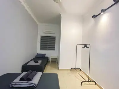 a room with two beds and a mirror in it at Homestay 2 @Taman Teluk Intan in Teluk Intan