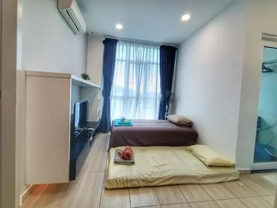 a bedroom with two beds and a window with a television at Awesome Suites 1, Netflix, Georgetown in Jelutong