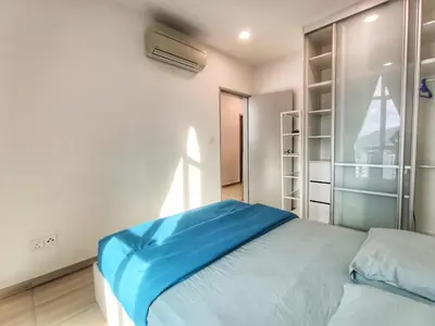 a bedroom with a blue bed and a window at Awesome Suites 1, Netflix, Georgetown in Jelutong