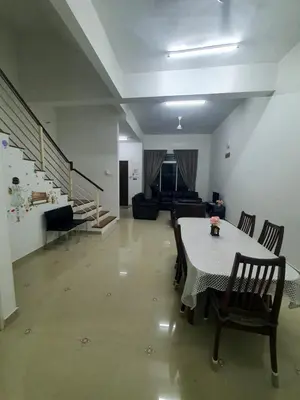 a living room with a table and chairs and a couch at Homestay Pohon Rendang in Balik Pulau