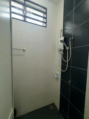 a shower with a glass door in a bathroom at Homestay Pohon Rendang in Balik Pulau