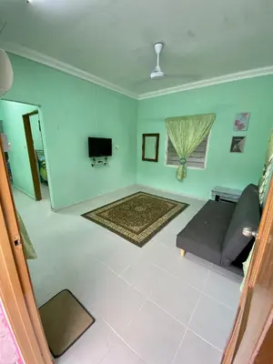 a living room with a couch and a tv at Rumah Comel in Kampung Degong