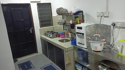 a kitchen with a counter top with a microwave at TokBi Homestay Gerik in Gerik