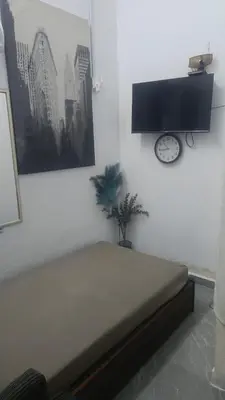 a bedroom with a bed and a clock on the wall at Mini Studio in Permatang Pauh