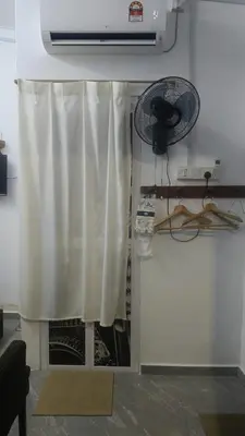 a room with a white curtain and a fan at Mini Studio in Permatang Pauh