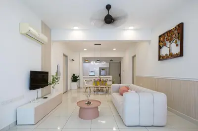 a living room with a white couch and a tv at The Jazz Serviced Suites in Tanjong Tokong
