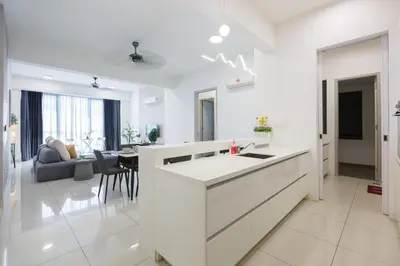 a white kitchen with a counter and a living room at The Jazz Serviced Suites in Tanjong Tokong
