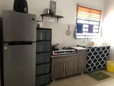 a kitchen with a refrigerator and a stove at Al Ghazali Homestay in Seri Iskandar