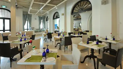 a restaurant with white tables and chairs and a cafeteria at Royale Chulan Penang in George Town