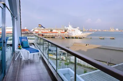 a balcony with a cruise ship in a harbor at Royale Chulan Penang in George Town